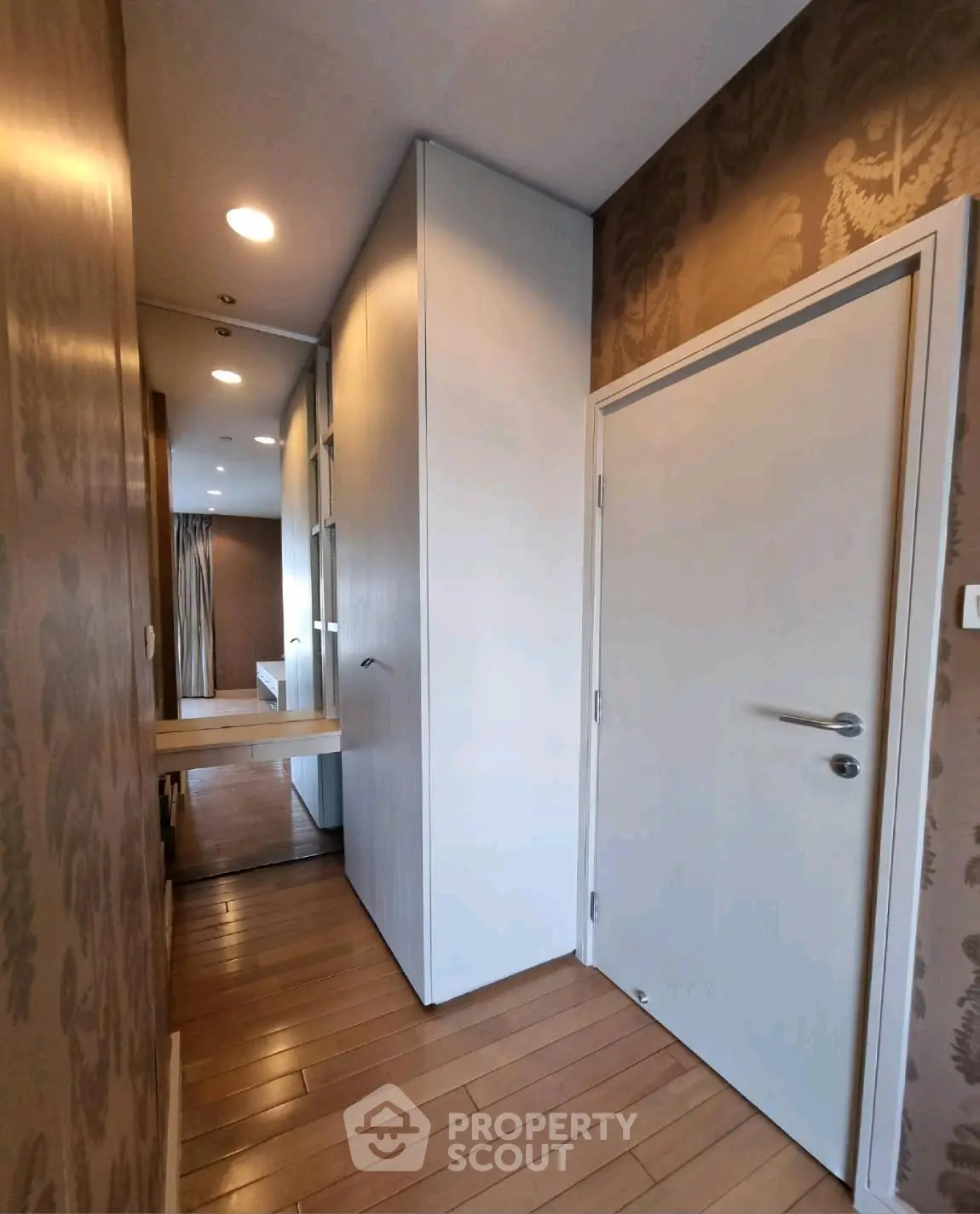 Stylish hallway with wooden flooring leading to a modern bedroom, featuring elegant wallpaper and sleek design.