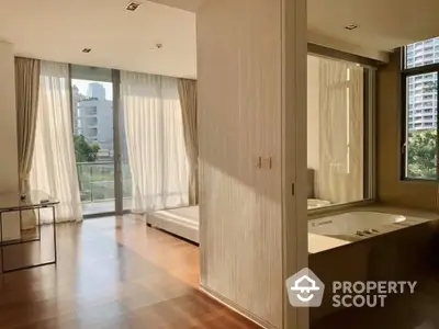 Sunlit spacious bedroom with large windows offering a serene view, featuring a built-in wardrobe and hardwood flooring, perfect for relaxation.