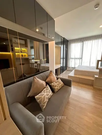 Modern studio apartment with sleek design and large windows for natural light.