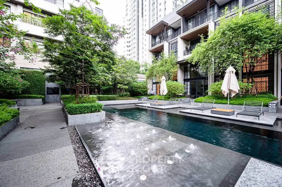 Luxurious modern apartment complex with serene pool and lush greenery
