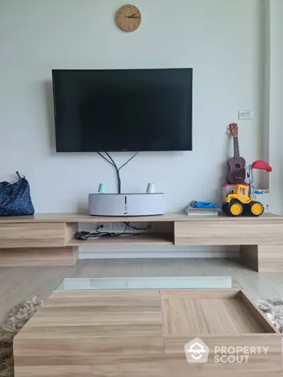 Modern living room with wall-mounted TV and stylish wooden furniture.