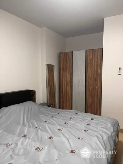 Cozy bedroom with modern wardrobe and stylish bedding in a contemporary apartment.