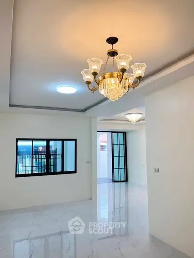 Spacious modern living room with elegant chandelier and marble flooring