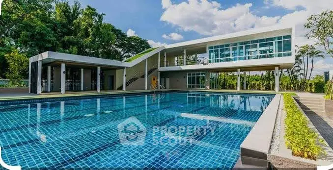 Luxurious modern building with a stunning outdoor pool and lush greenery, perfect for relaxation and leisure.