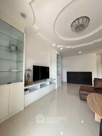 Spacious modern living room with sleek design and elegant ceiling chandelier.