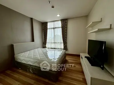 Modern bedroom with large window and wooden flooring in a stylish apartment.