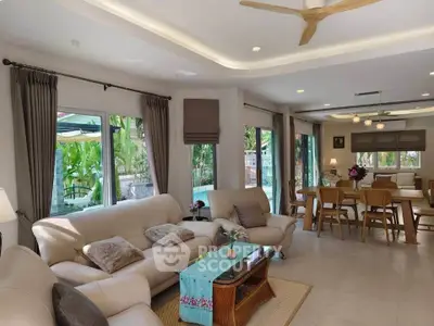 Spacious living room with elegant decor and pool view, perfect for family gatherings.