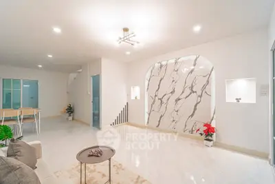 Modern living room with marble accent wall and stylish lighting