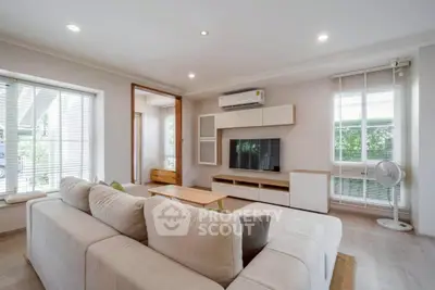 Spacious modern living room with cozy sofa and large windows for natural light.