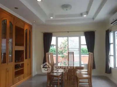 Elegant dining room with wooden furniture and large windows offering natural light.