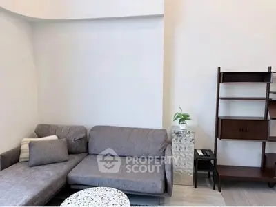 Modern living room with stylish gray sofa and elegant shelving unit