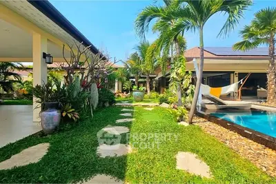 Luxurious tropical villa with lush garden and private pool, perfect for serene living.