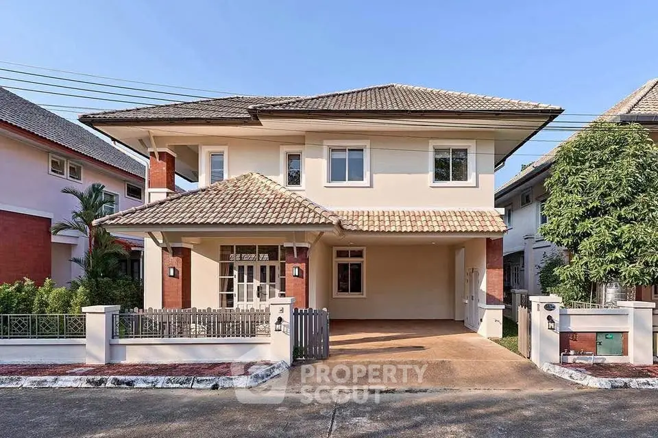 Charming two-story house with tiled roof and spacious driveway in a serene neighborhood.