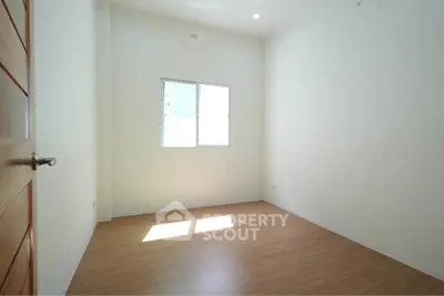 Bright and spacious empty room with wooden flooring and natural light