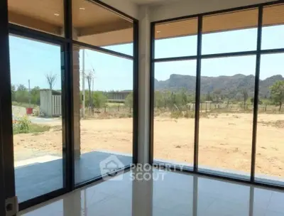 Spacious room with large windows offering stunning mountain views, perfect for natural light lovers.