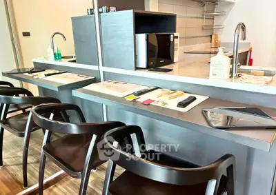 Modern kitchen with sleek bar seating and stainless steel appliances