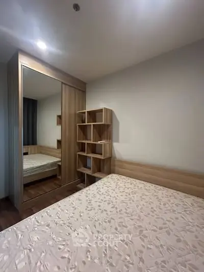 Cozy bedroom with modern wooden furniture and mirrored wardrobe