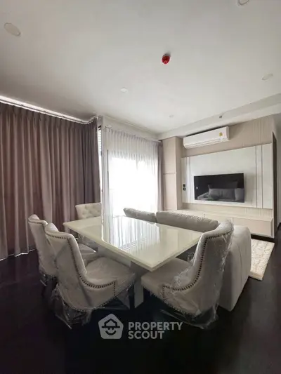 Elegant dining room with modern table and plush chairs, featuring floor-to-ceiling windows and stylish decor.