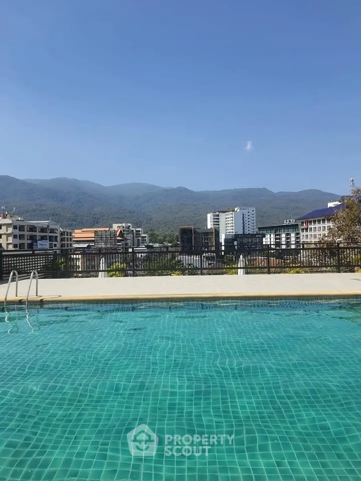 Stunning rooftop pool with panoramic mountain views in urban setting.