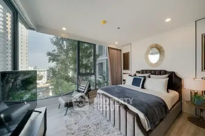 Luxurious bedroom with floor-to-ceiling windows and modern decor in high-rise apartment.