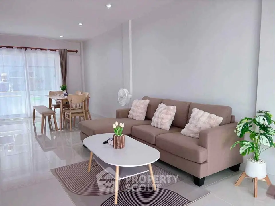 Spacious modern living room with cozy sofa and dining area, perfect for family gatherings.