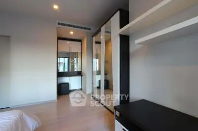 Modern bedroom with sleek mirrored wardrobe and minimalist decor