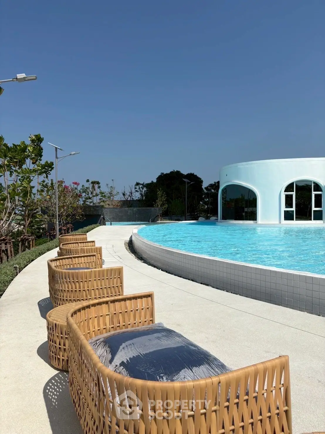 Luxurious outdoor pool area with modern seating and clear blue sky