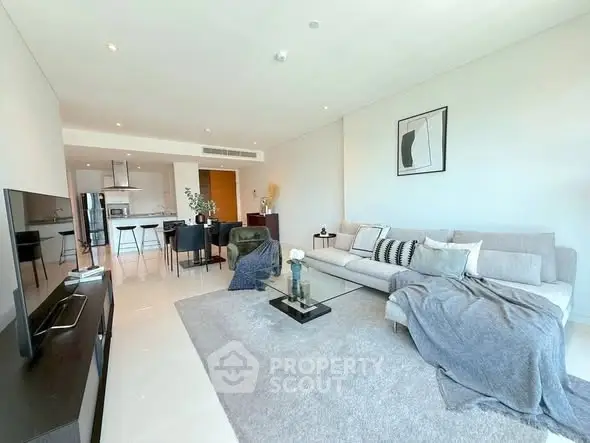 Spacious modern living room with open kitchen and stylish decor in luxury apartment.