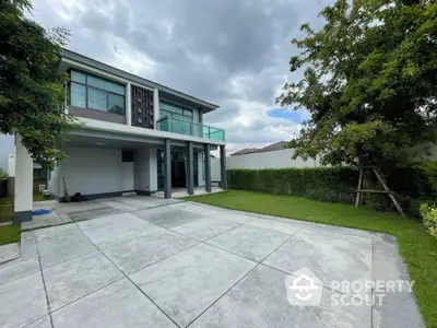 Modern two-story house with spacious driveway and lush green garden