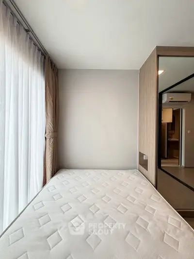 Modern bedroom with large window and minimalist design in a contemporary apartment.