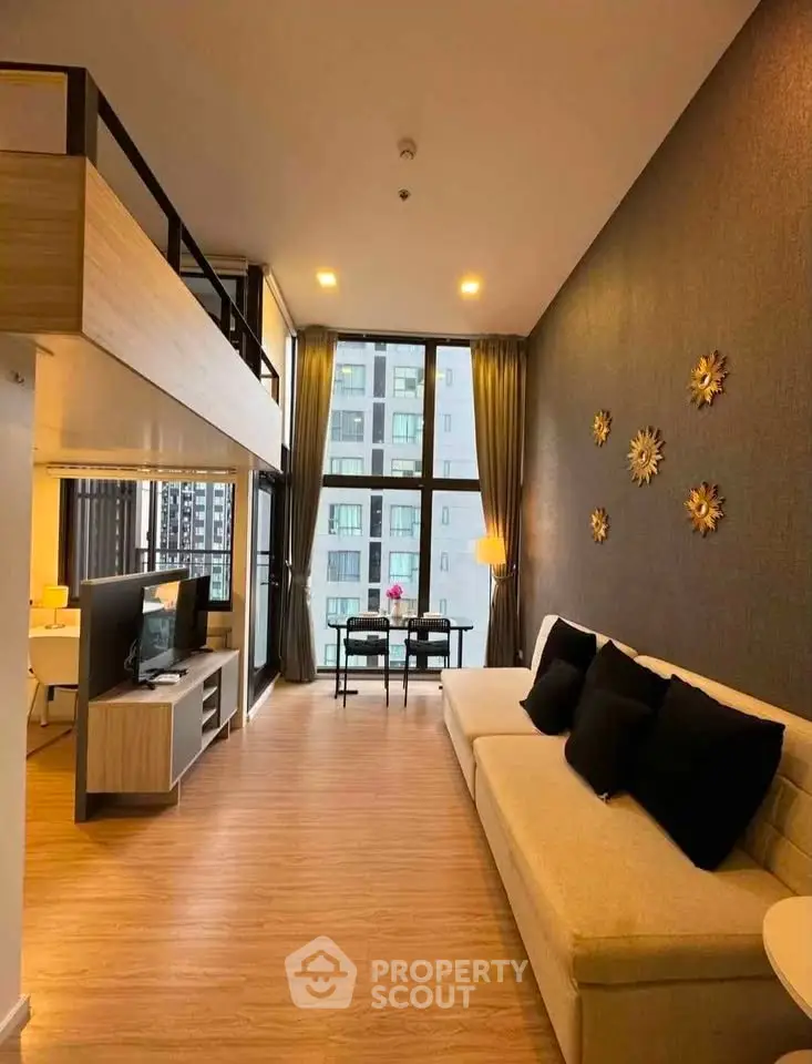 Modern loft-style living room with high ceilings and city view, featuring elegant decor and spacious layout.