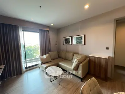 Modern living room with stylish decor and balcony view in a contemporary apartment.