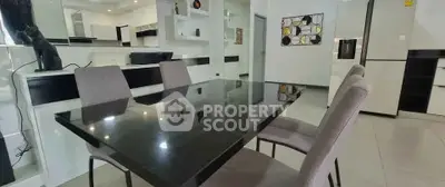 Modern dining area with sleek black table and stylish chairs in a contemporary kitchen setting.