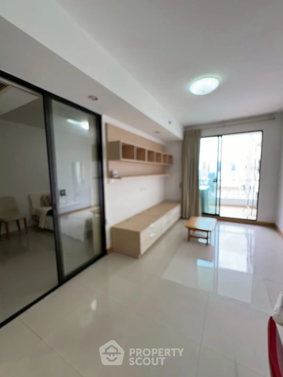 Modern living room with sleek design and natural light, featuring sliding glass doors and minimalist furniture.