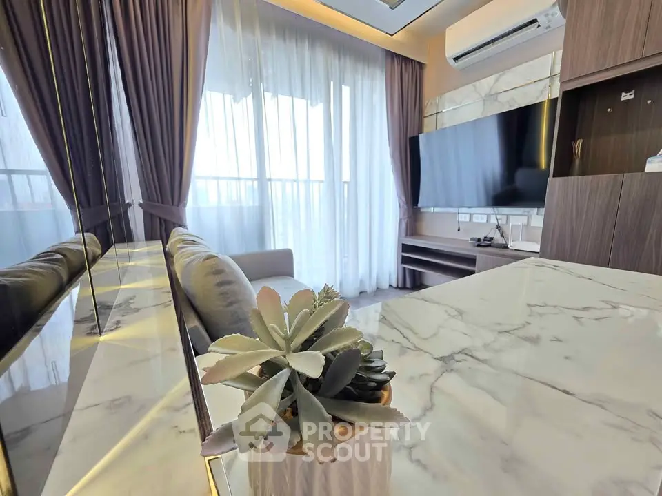 Luxurious modern living room with marble table and large TV, perfect for relaxation.
