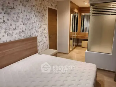 Modern bedroom with stylish wallpaper and mirrored wardrobe in a cozy apartment.