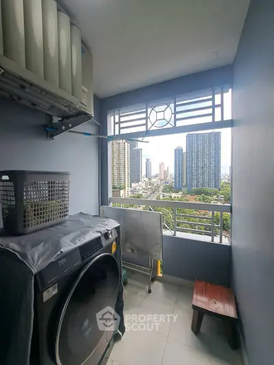 Charming balcony with laundry area and stunning city view in modern high-rise apartment.
