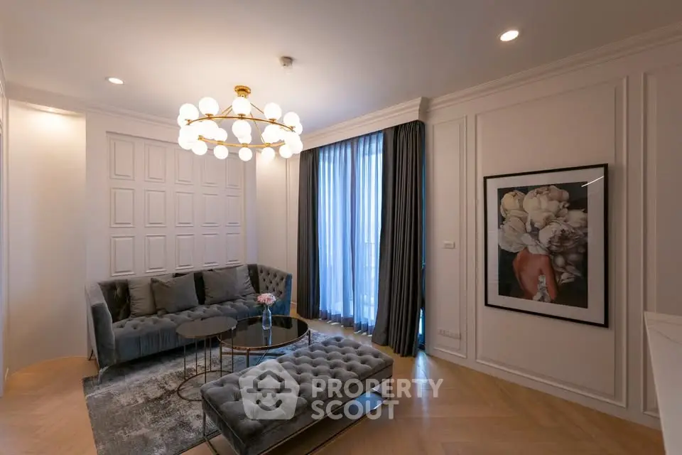 Luxurious living room with elegant chandelier and plush seating in modern apartment.