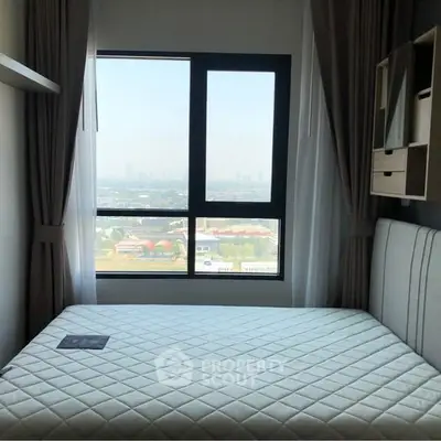 Cozy bedroom with large window offering stunning city view, perfect for relaxation and comfort.