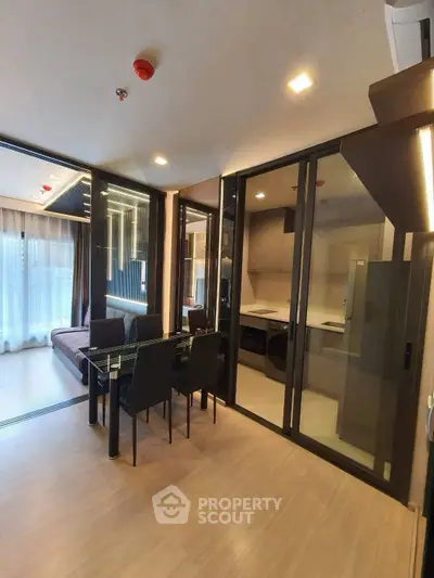 Modern open-plan living and dining area with glass partition and sleek furnishings