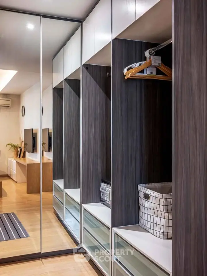 Spacious modern closet with mirrored doors and ample storage in a stylish bedroom.