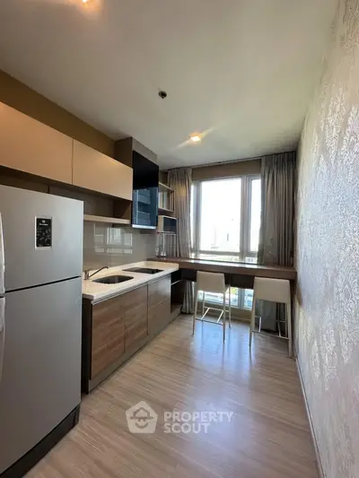 Modern kitchen with sleek cabinetry and large window offering natural light