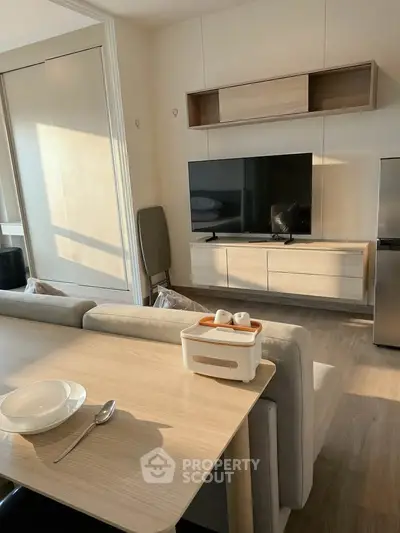 Modern living room with sleek furniture and large TV, perfect for relaxation and entertainment.