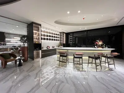 Luxurious modern kitchen with marble flooring, sleek countertops, and a well-appointed bar area with stylish seating.