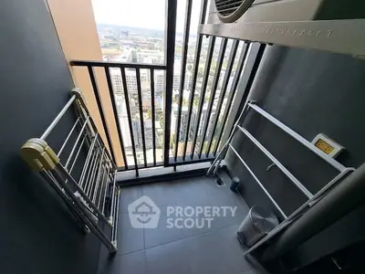 High-rise balcony with city view and metal railings, perfect for urban living.