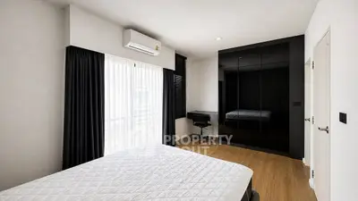 Modern bedroom with sleek black wardrobe and natural light