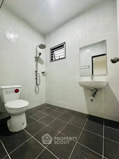 Modern bathroom with sleek tiles and contemporary fixtures in a real estate property.