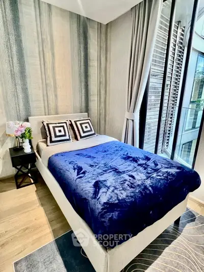 Modern bedroom with stylish decor and large windows for natural light.