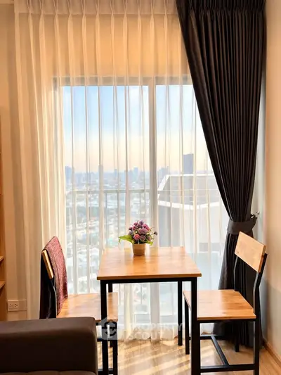 Charming dining nook with city view, featuring a cozy table set by a large window with elegant curtains.