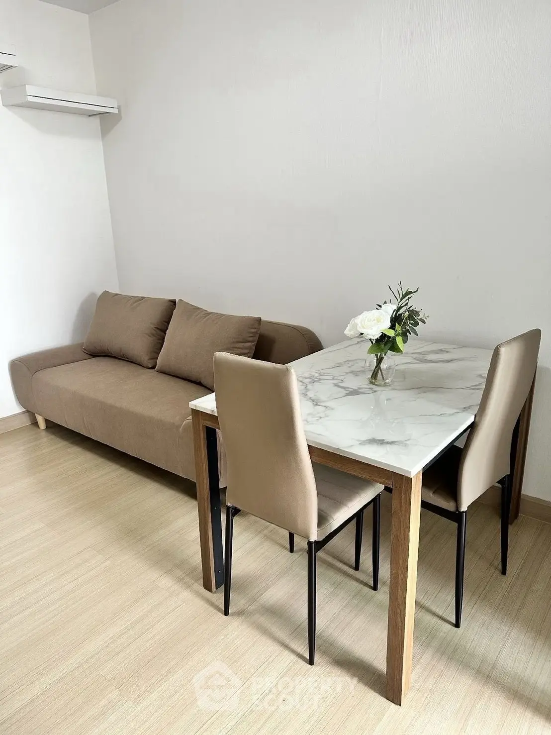 Modern living room with sleek sofa and elegant dining table, perfect for cozy gatherings.